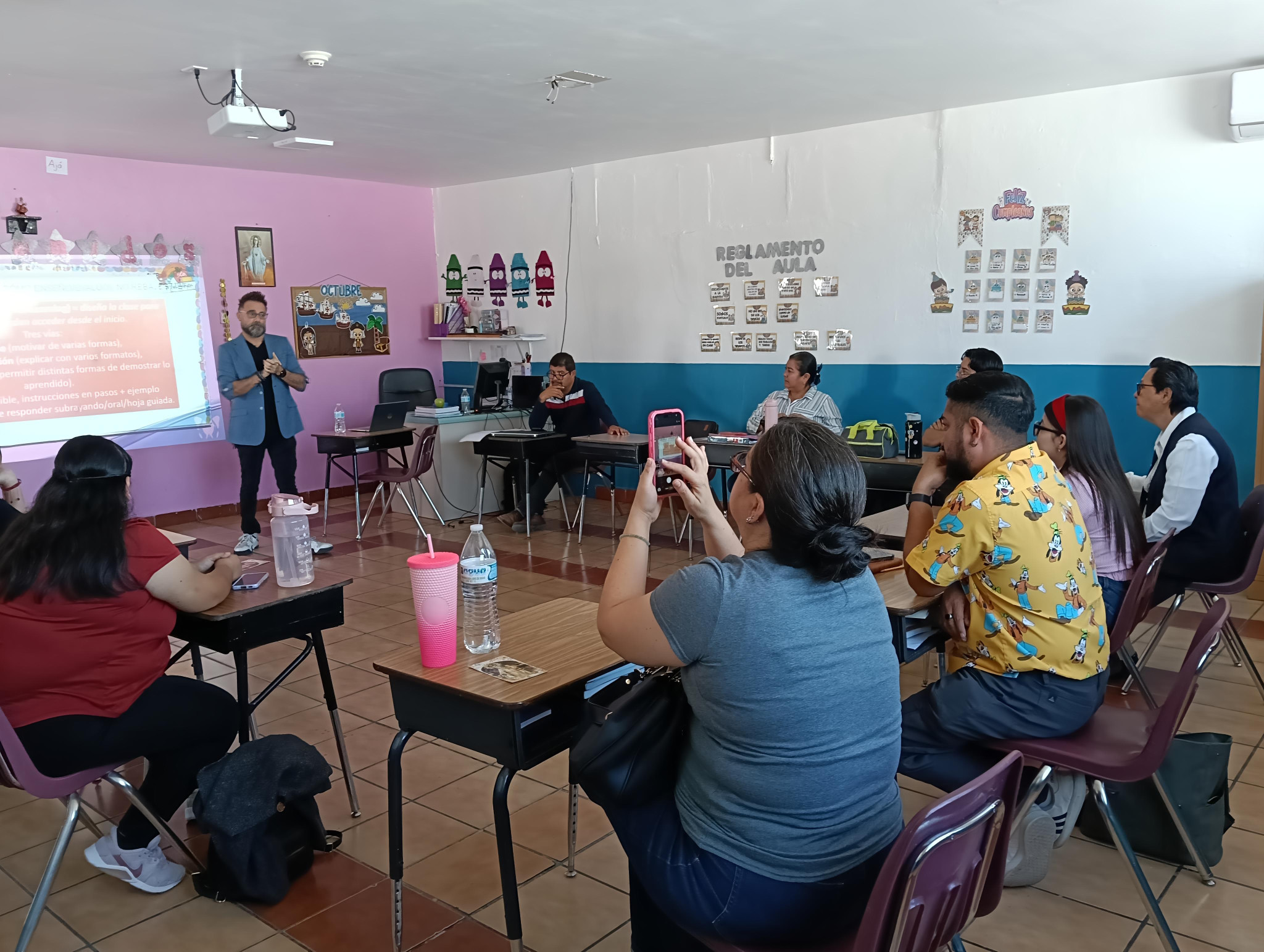 Oscar comparte una presentación con un grupo de personas adultas en un aula